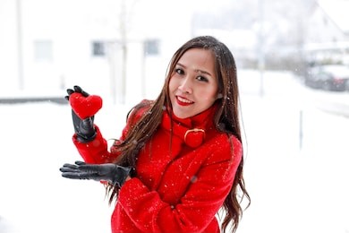 young asian woman with long hair holiday a red heart in her hands looking at camera and smiling on winter time.valentine’s day,mother’s day concept