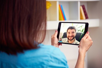 man and woman communicating through video chat on tablet pc