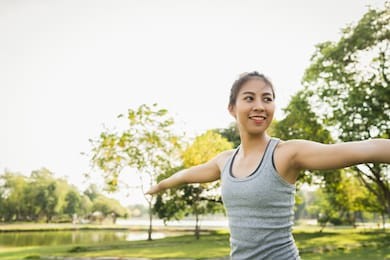 young asian woman yoga outdoors keep calm and meditates while practicing yoga to explore the inner peace. yoga have good benefits for health near lake at park. sport and healthy lifestyle concept.