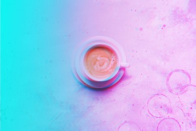 white cup fresh coffee scattered grains unhealthy food top view blue background. toned vibrant neon colors blue violet