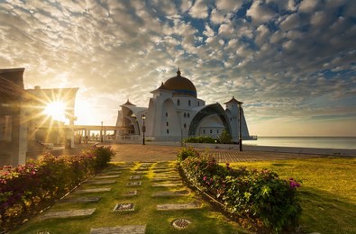 malacca straits mosque during sunrise with harsh sunlight - masjid selat melaka. it is a mosque located on the man-made malacca island near malacca town. malaysia