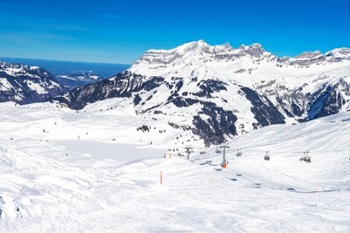 beautiful winter landscape with swiss alps. skiers skiing in famous engelgerg - titlis ski resort, switzerland, europe. 
