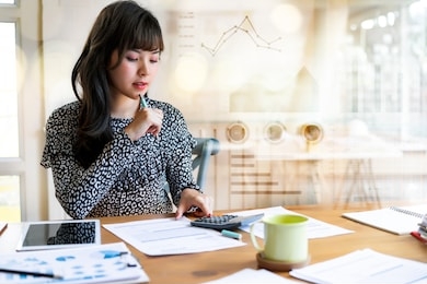 happy beautiful asian woman working about financial with business report and calculator.financial or accounting concept.