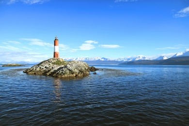 red and white striped les eclaireurs lighthouse on a rocky islands of beagle channel, ushuaia, tierra del fuego, patagonia, argentina