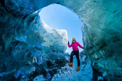 a girl with pink sweater adventure in ice cave in jokulsarlon, iceland. it is the famous place for tourism 