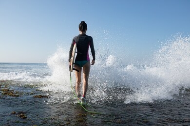 woman surfer with surfboard going to surf