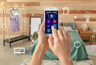 woman using mobile phone application of smart home automation in room