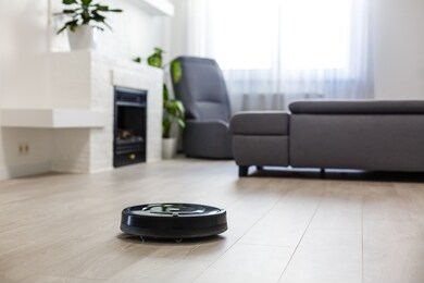 robotic vacuum cleaner on laminate wood floor in living room