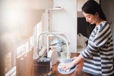 asian maid housewife washing cleaning dishes in kitchen
