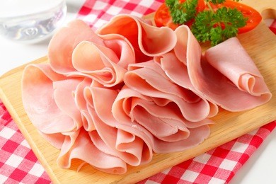 thinly sliced ham on cutting board