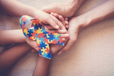 hands holding puzzle ribbon, world autism awareness day
