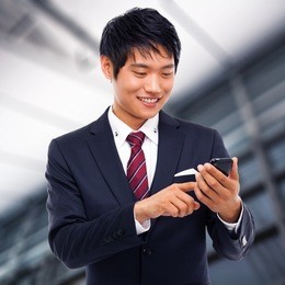 asian business man with cellphone in business background.
