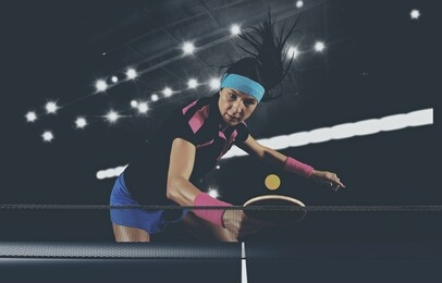 portrait young woman playing tennis on dark background with lights. matte image