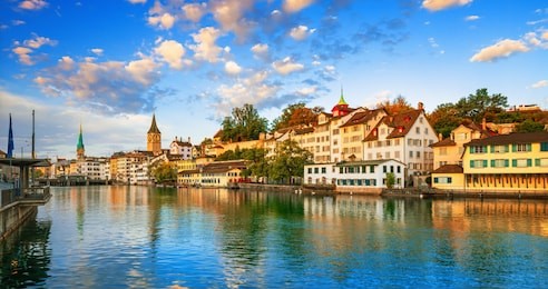 morning view of historic zurich city center with famous fraumunster and grossmunster churches and river limmat at lake zurich on a sunny day with clouds in summer, canton of zurich, switzerland