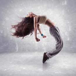 young woman hip hop dancer with grunge wall background texture