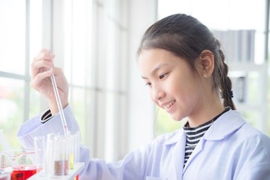 young asian school girl doing chemistry experiment in laboratory classroom. education concept.