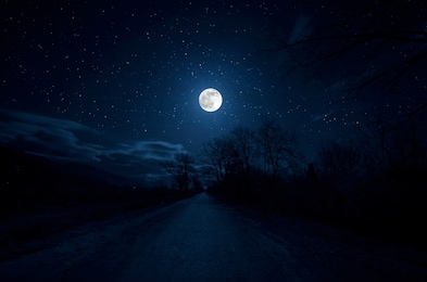 mountain road through the forest on a full moon night. scenic night landscape of country road at night with large moon