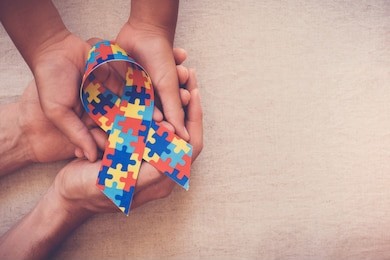 hands holding puzzle ribbon for world autism awareness day, pride, jigsaw