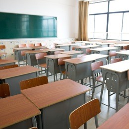 empty classroom with chairs, desks and chalkboard.