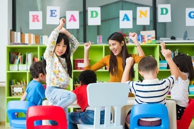 happy asian female teacher and mixed race kids in classroom,kindergarten pre school concept