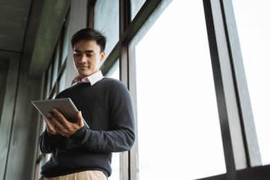 handsome asian young businessman using tablet pc