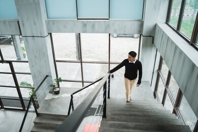 asian businessman walking up on the stairs go to his room in the upstairs the building