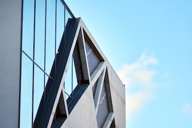 abstract image of looking up at modern glass and concrete building. architectural exterior detail of office building. 