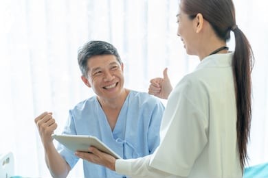 asian senior patient on hospital bed discussing with female doctor - selective focus point