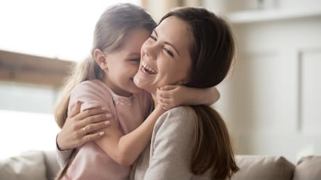 loving young mother laughing embracing smiling cute funny kid daughter enjoying time together at home, happy family single mom with little child girl having fun playing feel joy cuddling and hugging