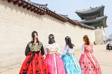 gyeongbok palace, women wearing traditional hanbok costumes, walking in the old palace with beautiful architecture one of the places to visit korea, seoul, south korea.