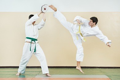 two young adult people in kimono training taekwondo martial art at gym