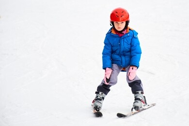 child skiing in mountains. active toddler kid with safety helmet, goggles and poles. ski race for young children. winter sport for family. kids ski lesson in alpine school. little skier racing in snow