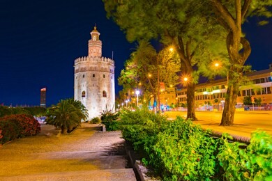 view of golden tower, torre del oro, of seville, andalusia, spain over river guadalquivir at sunset