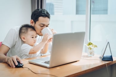 working from home of asian little son helping father drinking coffee between working with laptop computer notebook at workplace happy family together at home concept.