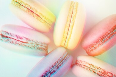 row of colorful macarons on turquoise background. top view, close up, 3d effect, toned image.