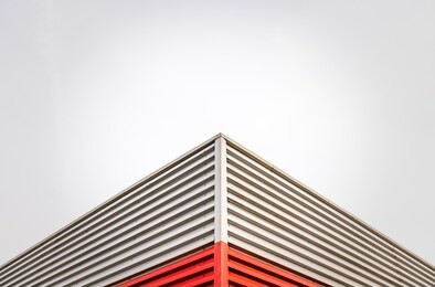 abstract architecture detail of a factory roof corner against an overcast sky with copy space