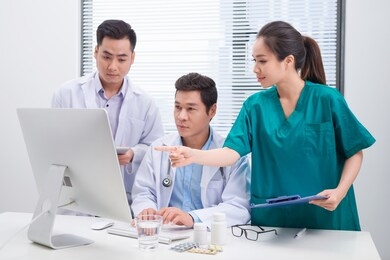 three doctors discussing patient files on office.
