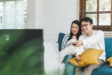 asian couple lifestyle, man and woman watching tv movies at home, family lifestyle relax and recreation concept