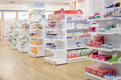 medicines arranged in shelves, pharmacy drugstore retail interior blur abstract backbround with medicine healthcare product on cabinet with neon light.