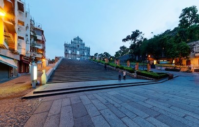 scenery of the ruins of st. paul's church in the historic center of macau, china, with a paved promenade & a stairway leading to the beautiful facade of the historical architecture in morning twilight