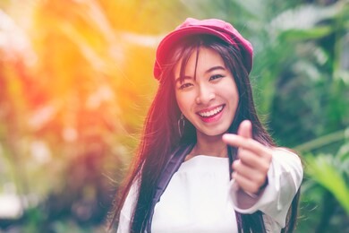 portrait of young relaxing asian girl feeling freedom raised her hands in the air, beautiful smiling carefree woman in the nature park with happy emotion. woman lifestyle, people freedom style.