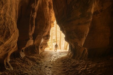 man stands in chapel cave in a remote part of southeast ohio. 
