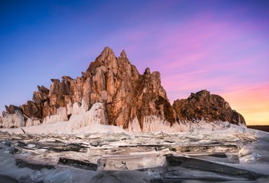 landscape view of baikal lake winter with colorful sunset sky background, shamanka cape, burkhan island olkhon at baikal lake, russia
