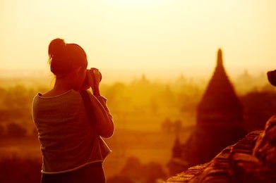 female traveler photographing temples at bagan myanmar asia at sunrise