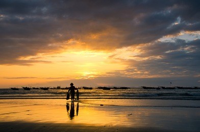fishermans are working in sunrise at my khe beach, danang, vietnam