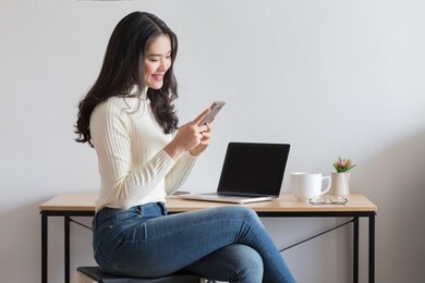 young happy asian woman using smart phone at the office.