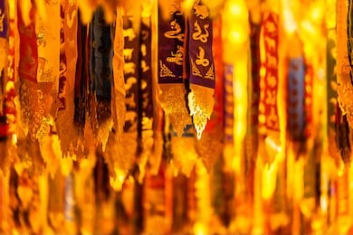 a lot of colorful buddhist flags or scrolls hanging from the ceiling of the wat chedi luang worawihan in chiang mai, thailand