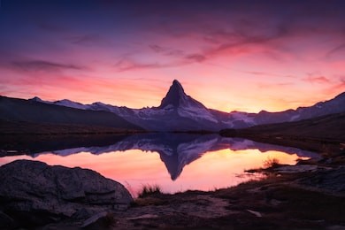 picturesque landscape with colorful sunrise on stellisee lake. snowy matterhorn cervino peak with reflection in clear water. zermatt, swiss alps