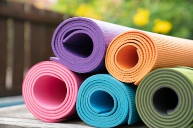 close up of colorful yoga mat on the table, sport and healthy concept