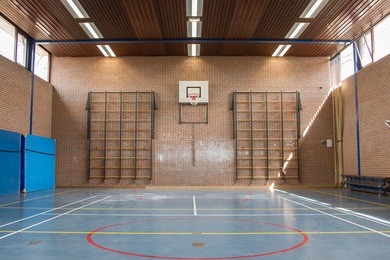 interior of a gym at school, jumping high at the basket